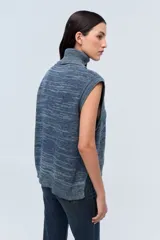 Chaleco de punto azul con cuello alto y diseño de trenzas.