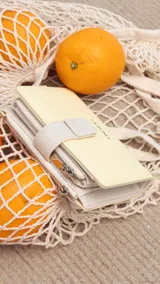 Billetera mediana de diseño compacto en color rosado, con cierre mediante presilla y compartimento adicional con cierre metálico. Presenta el logo de la marca grabado en el frente.