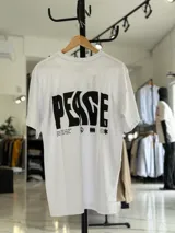 Remera oversize blanca de manga corta, con gran estampado negro en la espalda con la palabra 'Peace' y símbolos gráficos.