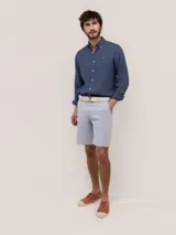 Bermuda de hombre de corte regular fit, color gris, con cierre de cremallera y botón, bolsillos laterales y traseros.