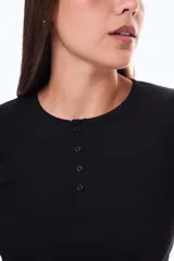 Remera de manga larga en tejido de punto acanalado, color blanco, con cuello redondo y cierre frontal parcial con botones.