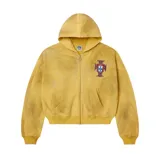Campera tipo hoodie con cierre frontal, de corte boxy y color amarillo con efecto desgastado. Presenta un escudo bordado en el pecho y detalles de pedrería brillante esparcidos por toda la prenda.