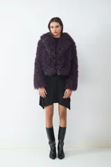 Campera corta de pelo sintético con textura rizada y voluminosa, de corte holgado y diseño envolvente.