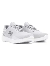 Championes de running Under Armour modelo Charged Escape 4, color gris claro con detalles en blanco. Presentan parte superior de malla técnica transpirable, contrafuerte externo en el talón para mayor sujeción y mediasuela con tecnología Charged Cushioning para una amortiguación óptima.