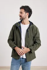 Campera de hombre color verde militar, con capucha forrada en azul marino, cierre frontal y puños ajustables con velcro.