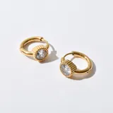 Aros dorados tipo argolla con dije circular con circonita engarzada.