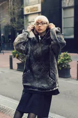 Canguro oversize de denim gris lavado, con capucha, cuello alto con cierre metálico, puños elásticos y bolsillo frontal tipo canguro.