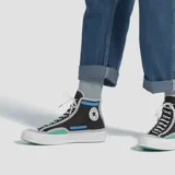 Championes Converse modelo Chuck 70 Trail de caña alta, con diseño técnico en color negro, detalles en azul eléctrico, verde y beige. Presenta el icónico parche de la marca en el lateral y suela de goma blanca.