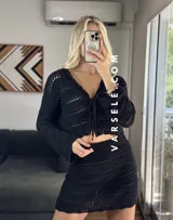 Conjunto de dos piezas tejido al crochet color crudo. Incluye una mini falda de tiro alto y un cardigan corto con mangas largas y lazos para atar en el frente.