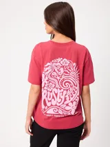 Remera de algodón con efecto tie-dye color rojo, corte holgado y estampa grande en la espalda de diseño psicodélico y playero con la marca Rusty.