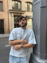 Remera celeste de corte holgado con estampado en la espalda que dice "Ittai Stars" en letras cursivas y "An Ibiza Produce" en mayúsculas.