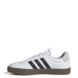 Championes Adidas VL Court 3.0 de hombre, color blanco con detalles en negro y gris. Presentan las tres tiras características de la marca en los laterales y suela marrón.