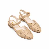 Sandalias planas de cuero color vainilla con tiras cruzadas, tachas metalizadas decorativas y tira con hebilla ajustable al tobillo.