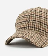 Gorra de béisbol con visera curva, confeccionada en tejido de poliéster con estampado de cuadros tipo pied de poule en tonos tierra y verde. Cuenta con ajuste en la parte trasera.