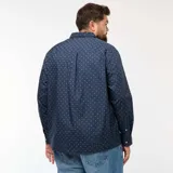 Camisa de corte recto y manga larga en color azul marino, con estampado de pequeños motivos blancos. Presenta cuello clásico y cierre frontal con botones.