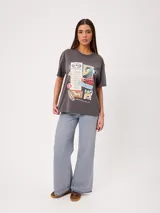 Remera de algodón gris con efecto de lavado ácido y corte holgado, con amplio estampado frontal de diseño inspirado en surf y estilo vintage.