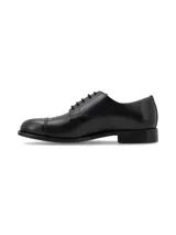 Zapato tipo Oxford de cuero negro con cordones, diseño de puntera reforzada y suela de bloque bajo.