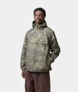 Chaqueta cortavientos tipo anorak con capucha, cierre parcial en el cuello y bolsillo canguro frontal. Presenta un estampado de camuflaje en tonos verdes y marrones.