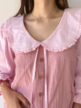 Camisa rosa con mangas 3/4 a rayas y cuello babero con volados.