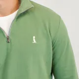 Buzo de algodón de punto en color verde, con cuello alto y cierre frontal parcial. Presenta puños y ruedo acanalados, con un pequeño logo bordado en el pecho.