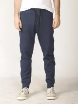 Pantalón jogging de corte slim, con puños elastizados, cintura con cordón ajustable, cierres laterales engomados y bolsillo tipo parche lateral.