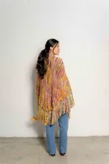 Chaleco tejido a crochet con flecos largos, diseño multicolor con predominancia de tonos tierra, naranja, amarillo y rosa.