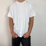 Remera básica de corte regular, color blanco, con cuello redondo y mangas cortas.