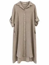 Camisola de lino beige, corte midi, con cuello camisero, cierre frontal con botones y mangas largas remangables. Cuenta con bolsillos laterales y dobladillo asimétrico más largo en la parte trasera.