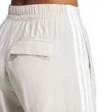 Pantalon Adidas de corte amplio y tiro alto, color beige con las icónicas tres tiras blancas laterales y logo de la marca bordado en la pierna. Cuenta con cintura elástica con cordón de ajuste.