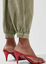 Jeans balloon de tiro medio color verde militar, con largo tobillero, pinzas y puños elásticos en los tobillos.