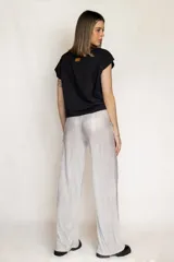 Pantalón de corte recto y tiro alto, confeccionado en tela plisada con acabado metalizado brillante en tono azulado. Presenta cintura elástica para mayor comodidad y ajuste.