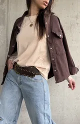 Remera manga larga de color beige, con cuello redondo y diseño bordado de flores en el hombro y lateral.