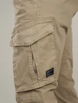 Pantalón cargo negro de sarga de algodón con spandex, con bolsillos laterales con solapa y etiqueta con el logo de la marca en uno de ellos.
