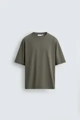 Camiseta boxy fit color verde militar con efecto lavado, confeccionada en tejido compacto de algodón con cuello redondo y manga corta.