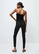 Jeans pushup de corte skinny y tiro bajo, en color negro. Presentan diseño de cinco bolsillos, trabillas para cinturón y cierre frontal con cremallera y botón.