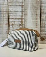 Neceser con cuerpo a rayas verticales azules y blancas, base y cierre superior de cuero color marrón.