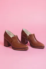 Zapato de cuero color marrón con elástico en los laterales y detalle de cuero texturizado en el talón y la suela.
