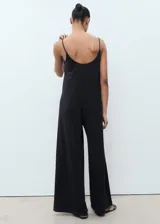 Mono largo de corte recto y diseño holgado, con escote redondo y tirantes finos. Incluye un cinturón de cordón fino ajustable en la cintura.