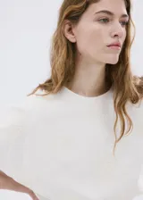Blusa crop de algodón color blanco con diseño estilo globo, detalles bordados, cuello redondo y manga corta.