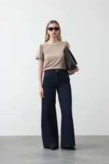 Remera de tejido acanalado color blanco, con cuello redondo y mangas cortas que presentan un detalle de terminación en puntilla en los bordes.