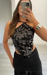 Top de escote halter con diseño triangular, completamente cubierto de lentejuelas circulares negras brillantes.