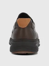 Zapato tipo slip-on de cuero marrón con paneles elásticos laterales para un ajuste cómodo y suela de goma oscura con diseño estriado.