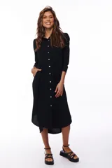 Vestido midi negro con corte camisero, abotonado al frente y con mangas 3/4. Tiene cuello clásico y bolsillos laterales.