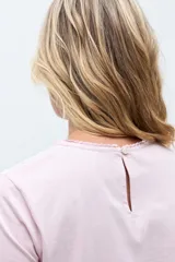 Remera de manga corta con frente confeccionado en tela broderie blanca con diseño calado y espalda de algodón liso.