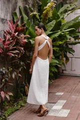 Vestido midi de algodón con diseño de bordado inglés perforado. Presenta escote en pico, diseño sin mangas y tirantes cruzados en la espalda con detalle de argolla.