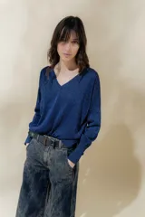 Sweater azul con brillo, escote en V y mangas largas.