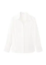 Camisa blanca de manga larga con detalles bordados calados en el frente y puños anchos.