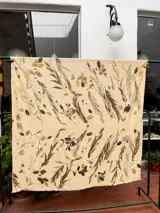 Mantel rectangular de viscosa color crema con estampado de hojas y flores en tonos marrones y dorados.