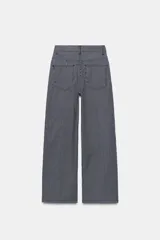 Jeans wide leg de tiro alto y diseño relaxed fit, confeccionados en denim azul marino con patrón de rayas verticales blancas. Cuenta con cinco bolsillos, cierre frontal con cremallera y botón, y detalle de nervio delantero con pespuntes a contraste.
