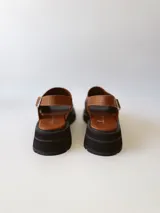 Sandalias de cuero color negro y marrón con textura tipo cocodrilo, con hebilla ajustable y suela track. Fabricadas en Uruguay.